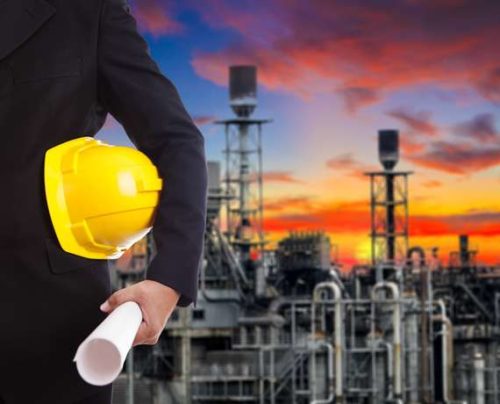 Boltog engineer holding a hard hat and drawings at a processing facility